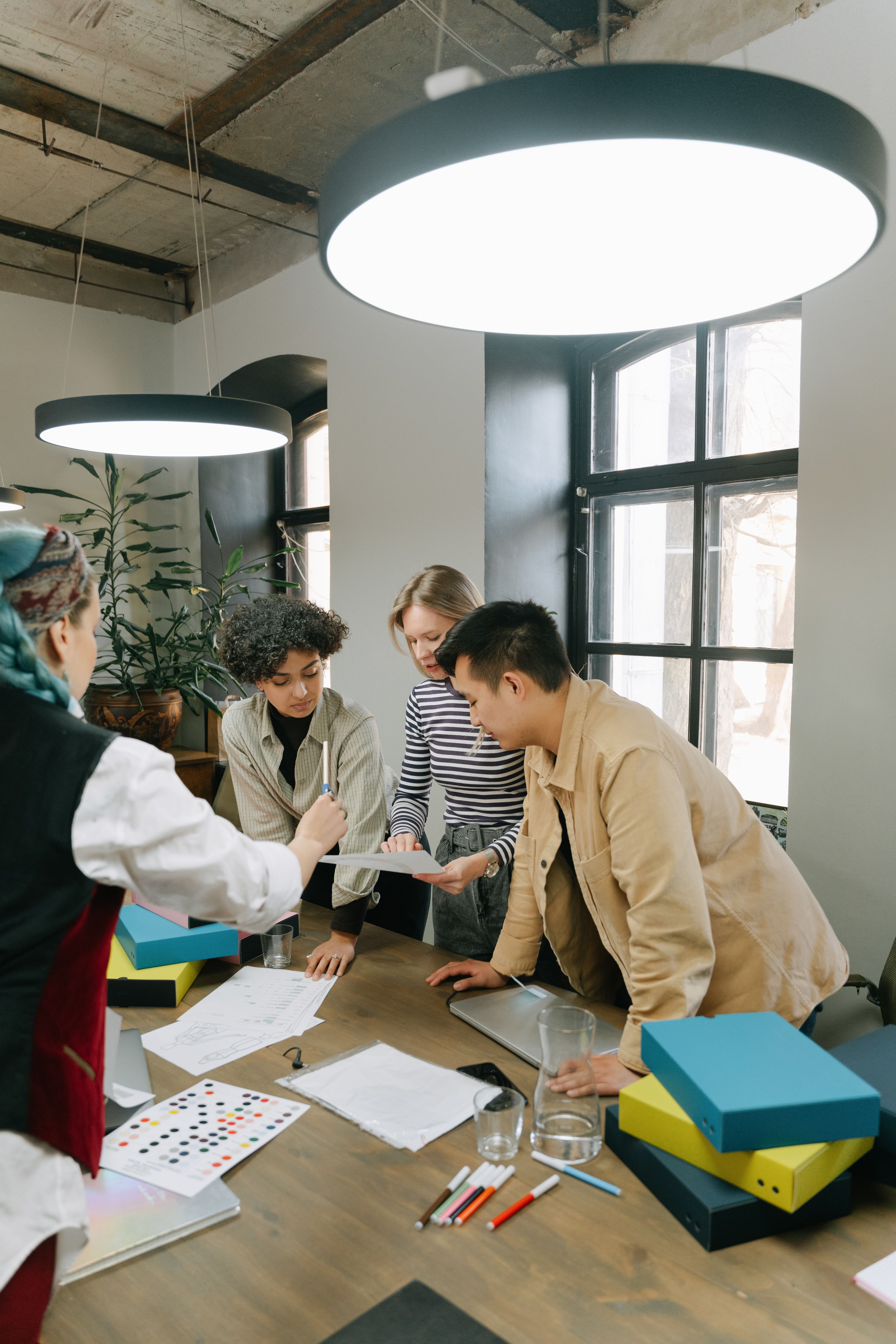 Diverse team of young professionals brainstorming together in a contemporary office