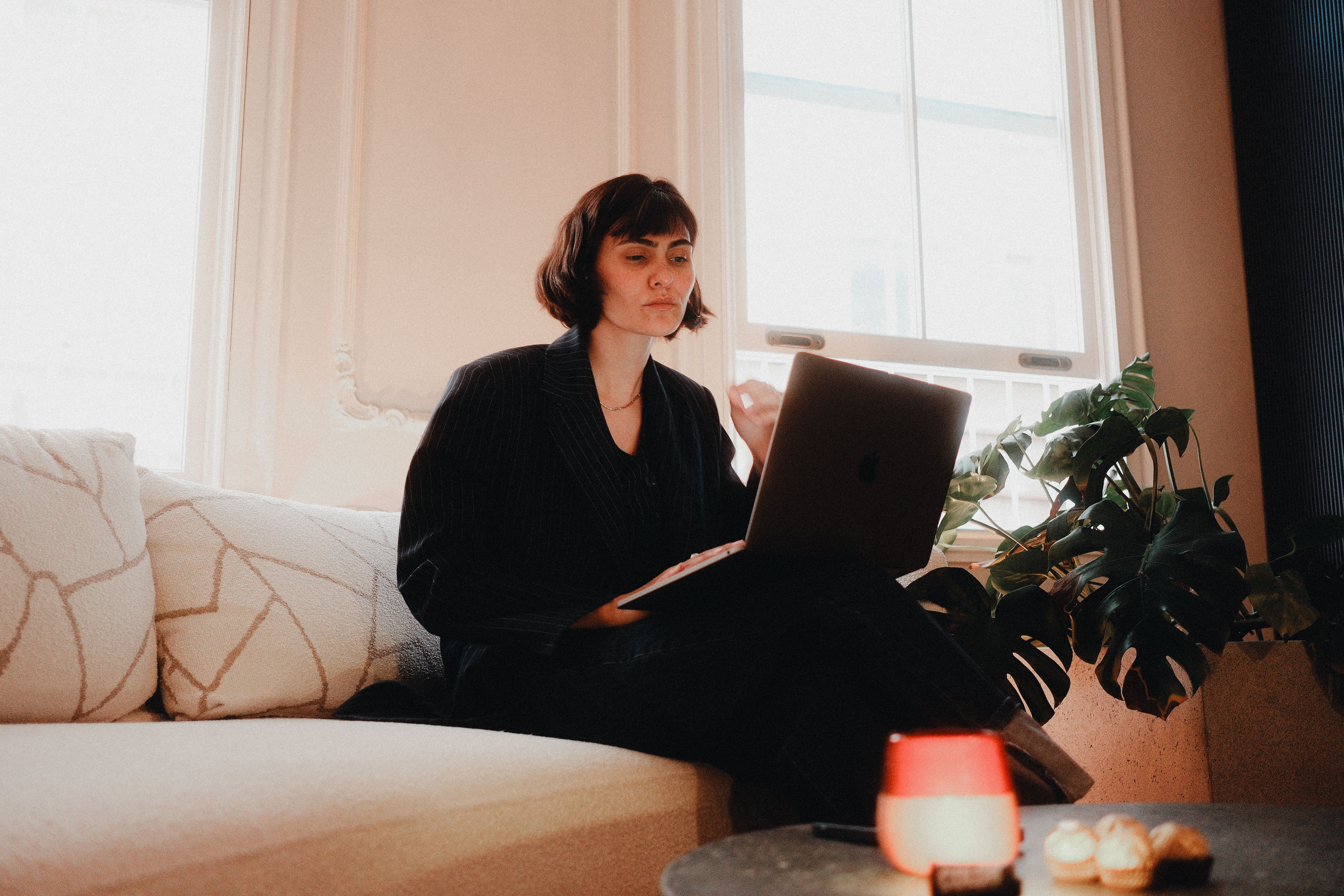 Woman in business attire working on a laptop from home