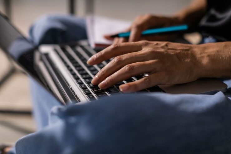 Close-up of a person typing on a laptop, symbolizing technology and remote work.