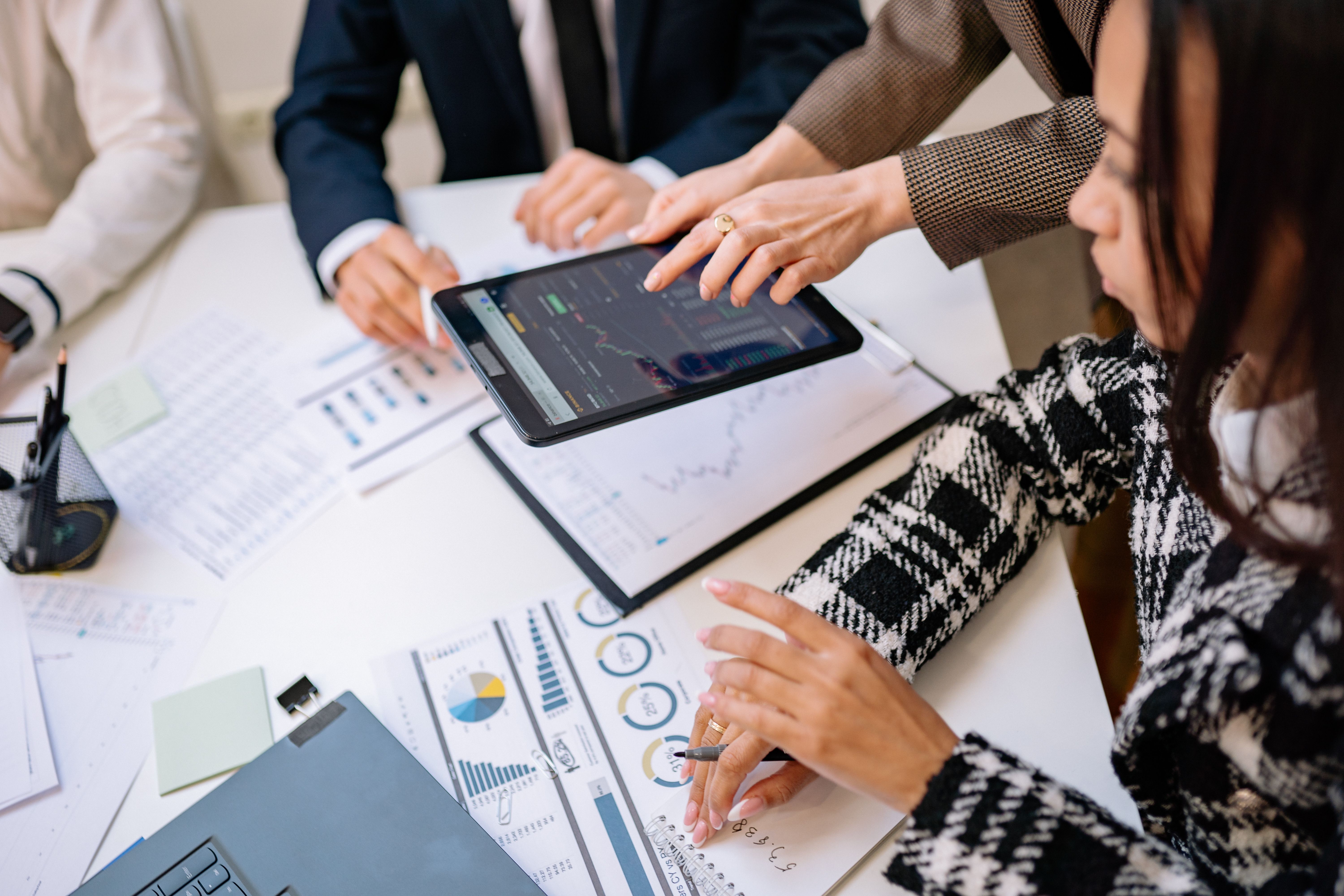 Business professionals reviewing analytics on a tablet during a meeting