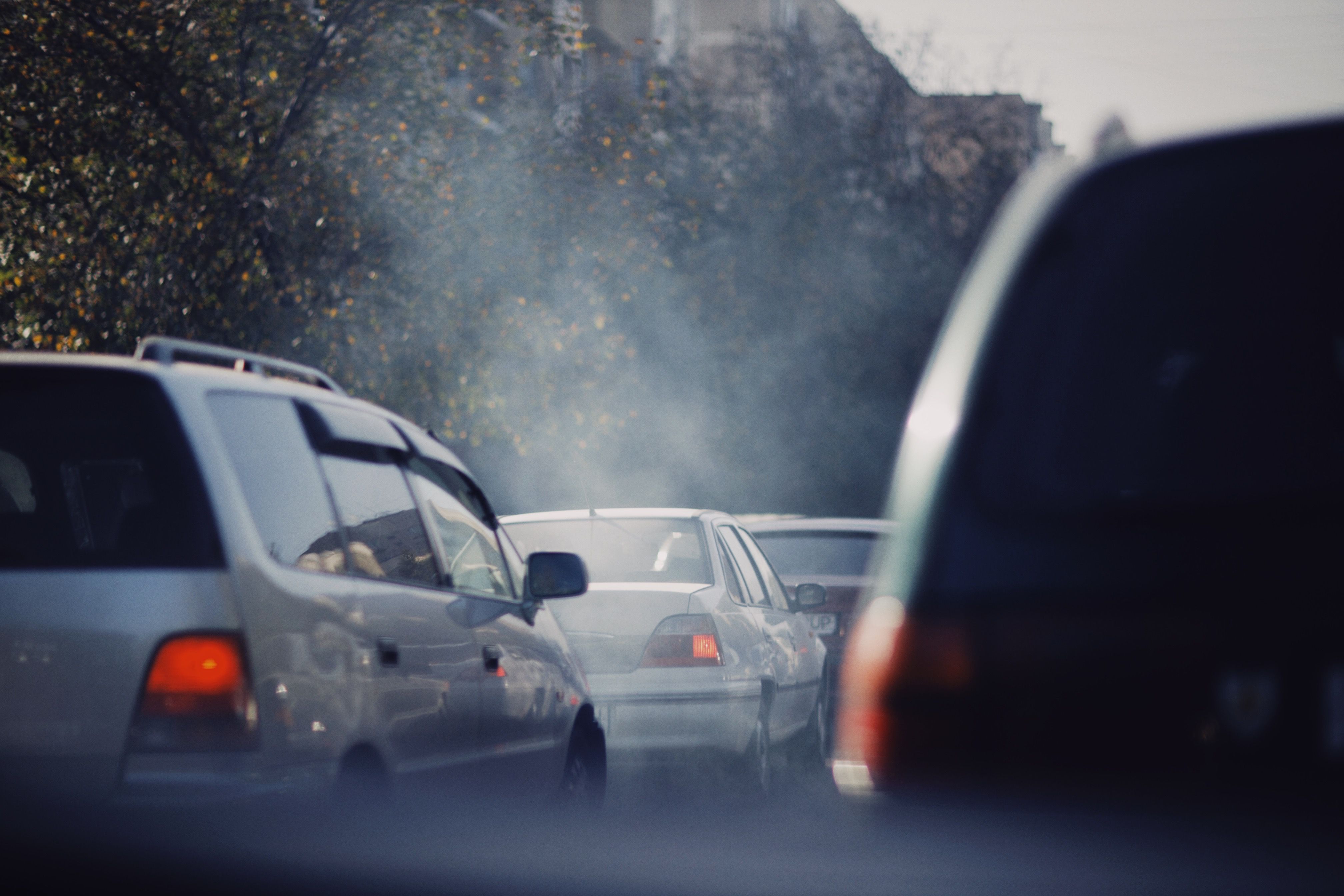 City traffic jam with vehicles emitting exhaust smoke on a busy road