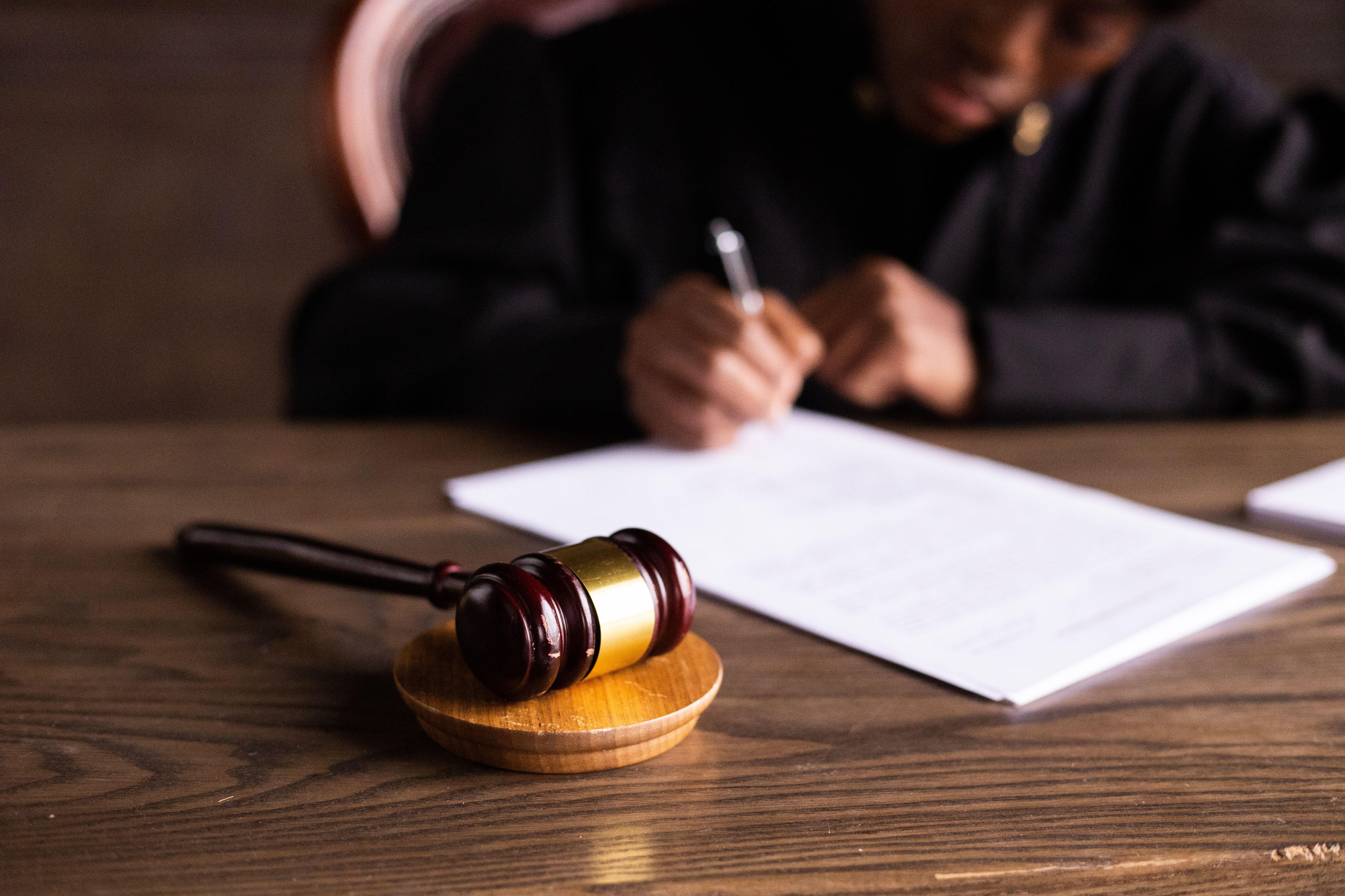 Judge signing legal documents at a desk with a gavel, representing mass disaster lawsuits