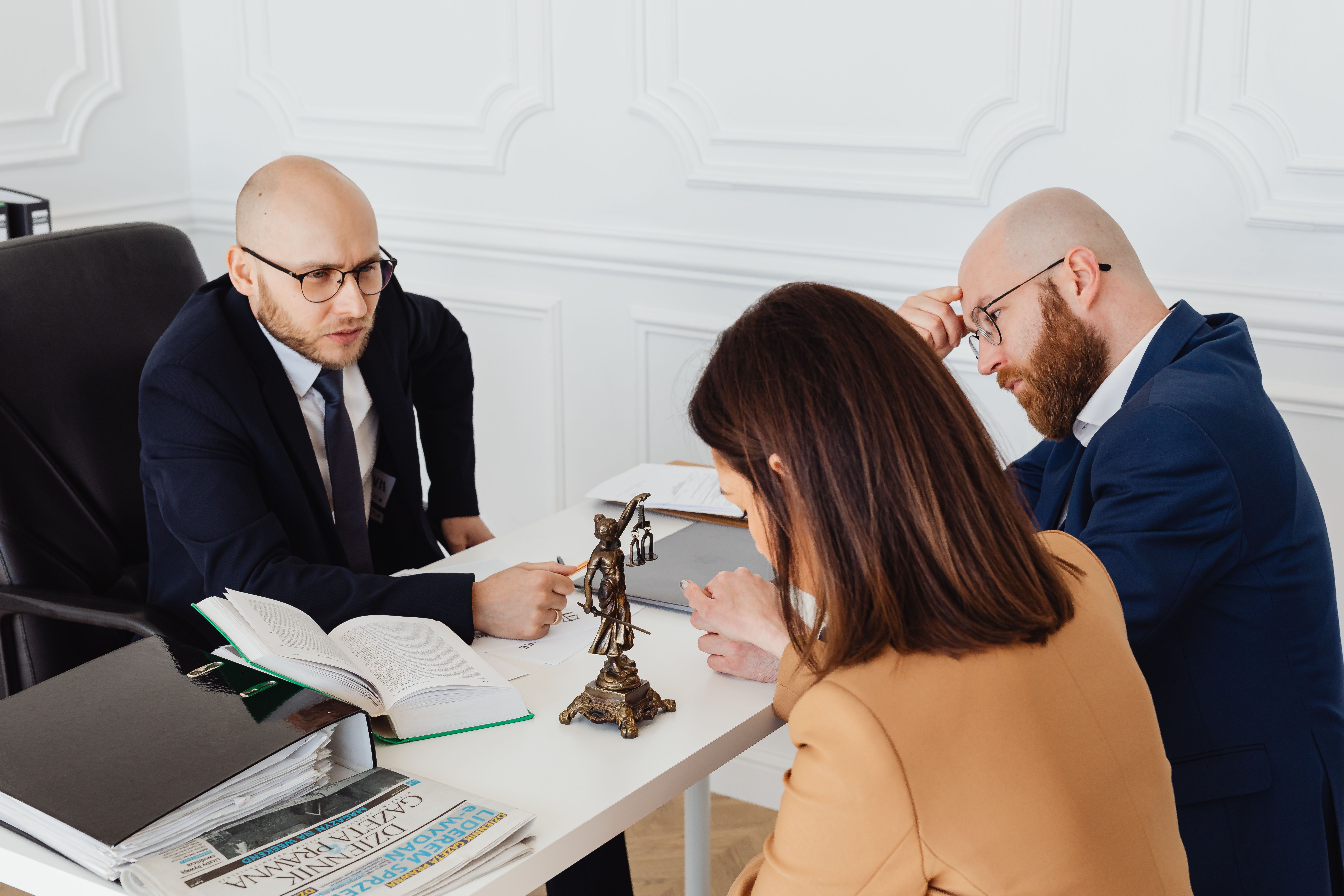 Lawyer consulting clients in a modern office, explaining a no win no fee group claim
