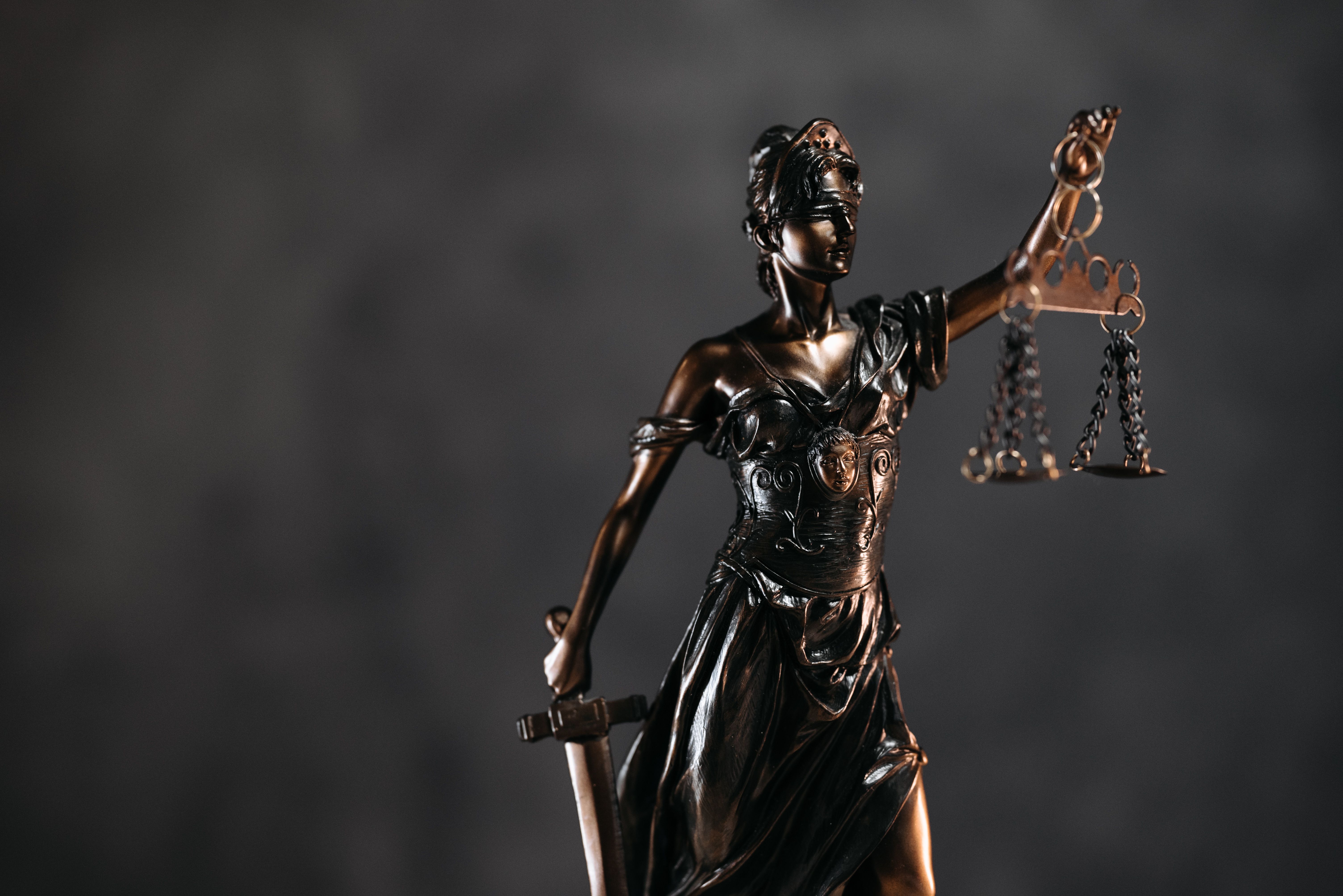 Bronze Lady Justice statue with scales symbolizing fairness and legal accountability