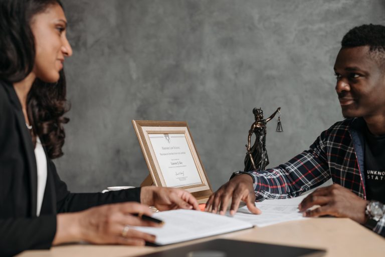 Two professionals discussing legal documents during a consumer rights consultation