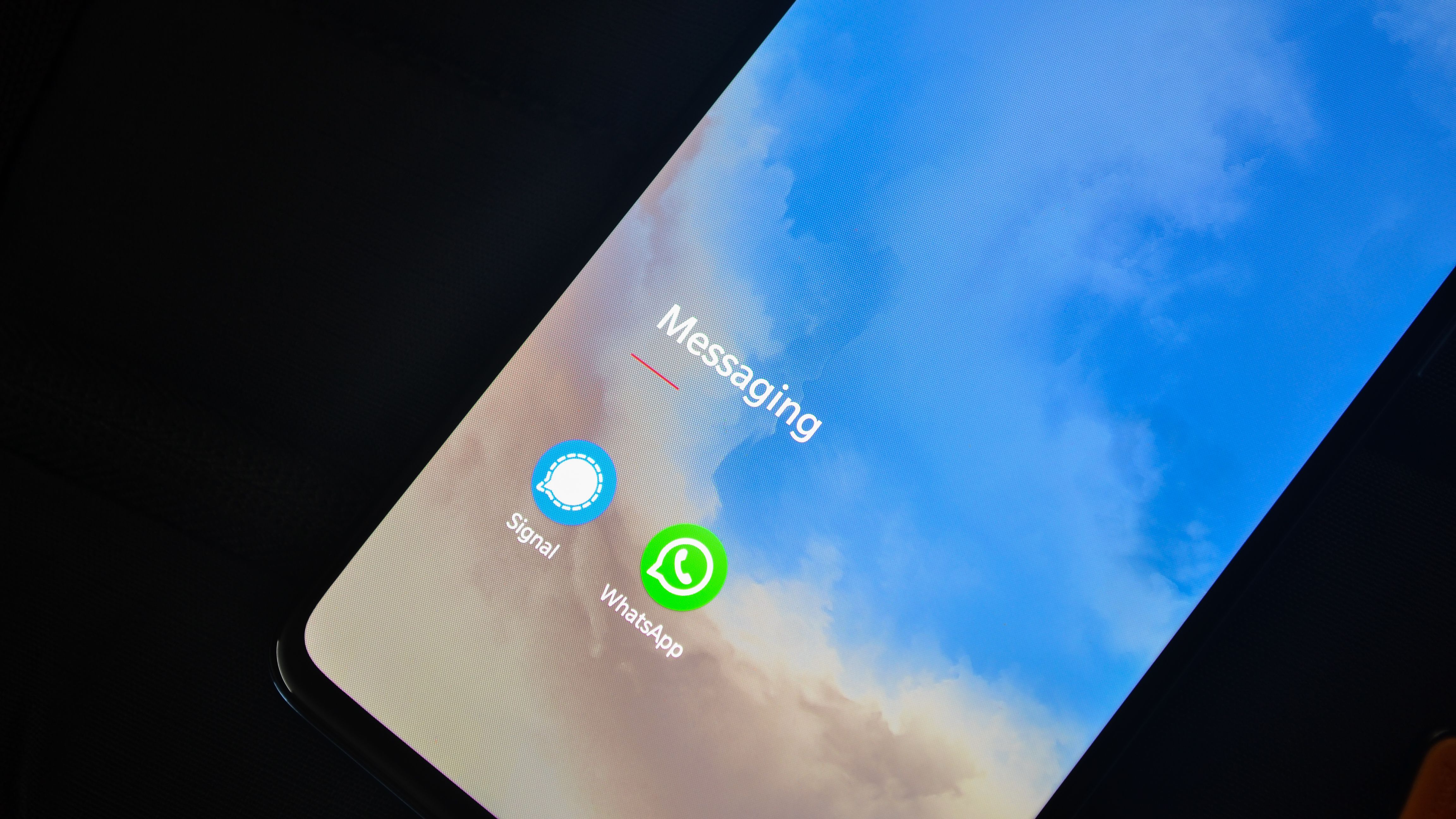 Close-up of a smartphone displaying messaging applications, illustrating secure communications monitoring