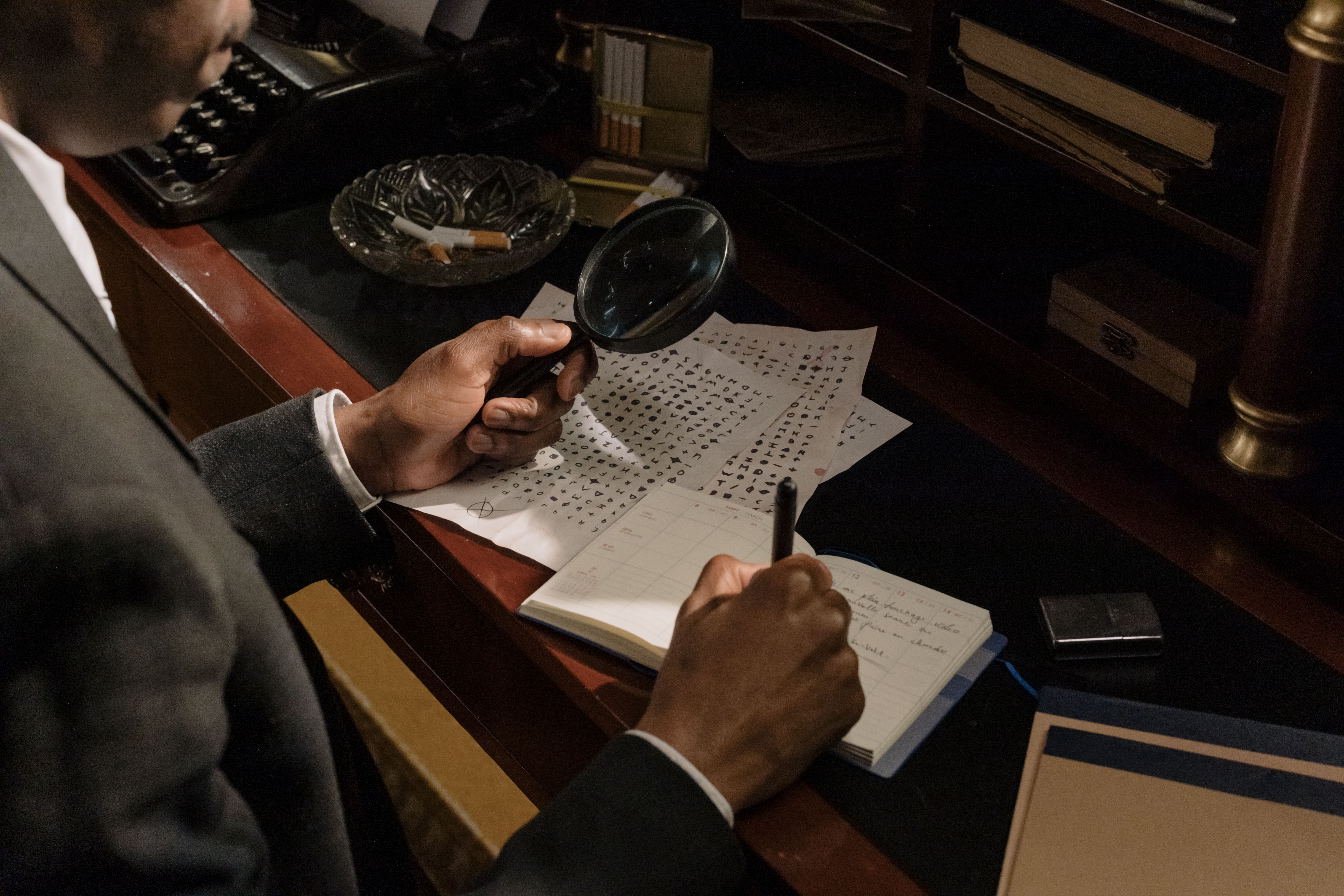 Investigator using a magnifying glass to examine documents and clues