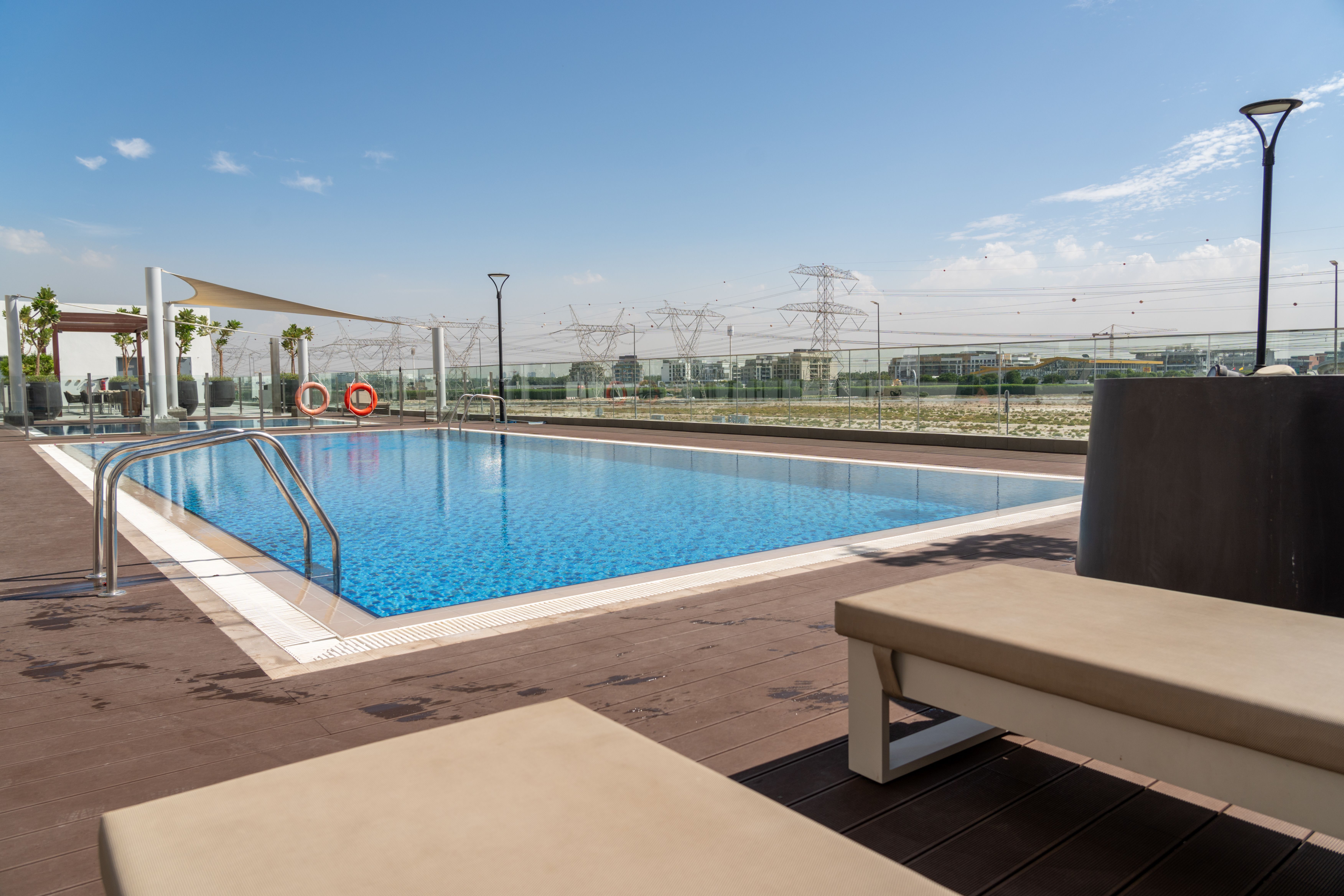 Rooftop swimming pool overlooking the Dubai skyline, a visual for premium residential amenities and city views.