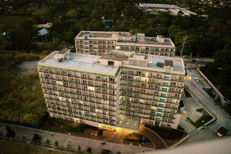 Aerial view of a modern residential high-rise complex in an urban setting at dusk, illustrating the Serra Residences’ exclusive city address.