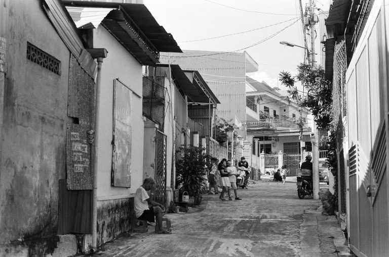 Vibrant street life in Pleiku, Vietnam, with residents, motorcycles, and local architecture.